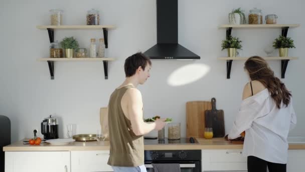 Jeune homme une femme préparer le petit déjeuner dans la bonne humeur et la danse — Video