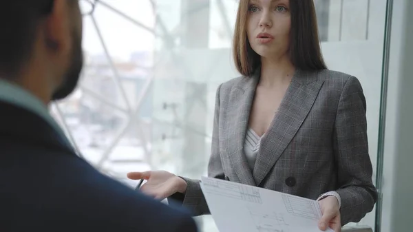 Business woman communicates with partner, smiles, holding a document. Stock Photo