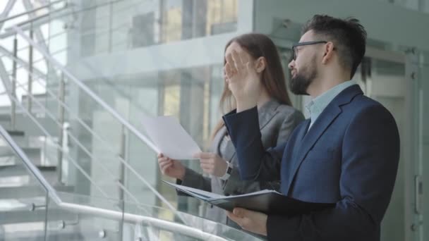 Framgångsrika affärsfolk diskuterar SMTH, stående nära räcke — Stockvideo