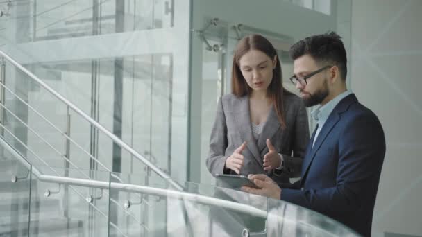 Muž a žena v oblecích diskutují obchodní záležitosti s tabulátorem — Stock video