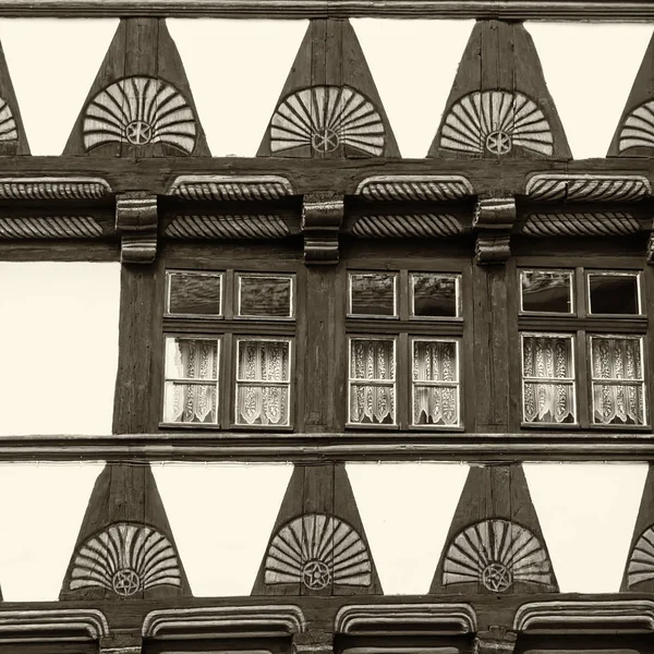 Close-up of timbered houses with fanlike frieze in monochrome