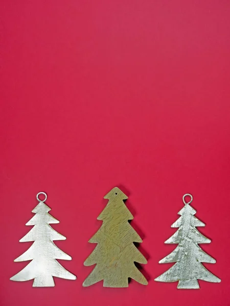 Christmas background from three fir trees isolated on red