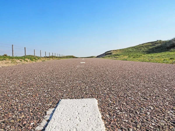Paved cycle track with dividing line in the Amsterdam water supply dunes near to Amsterdam and Zandvoort