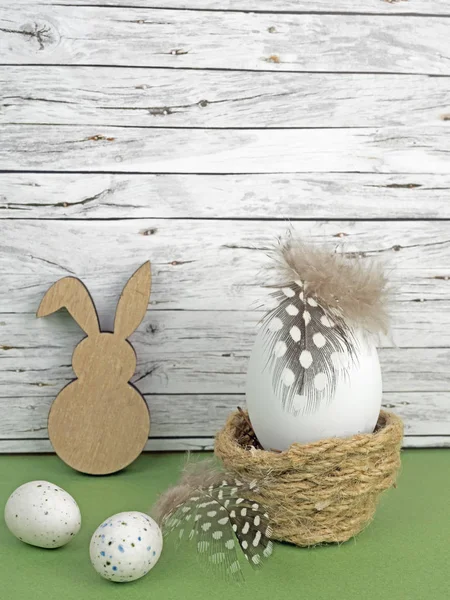 Easter background with Easter eggs and Easter bunny isolated on green in front of wood