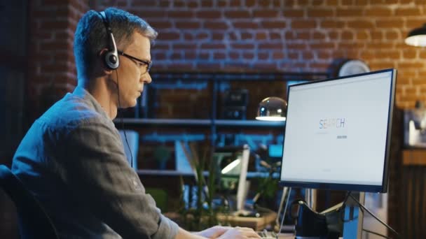 Man in hoofdtelefoon surfen op Internet in kantoor — Stockvideo