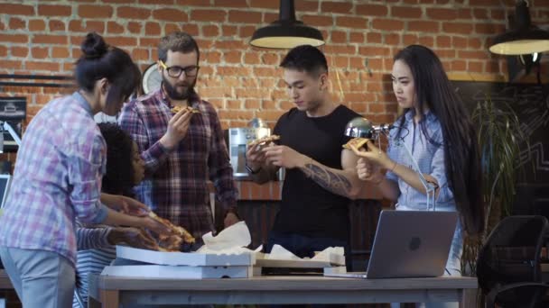 Chers collègues au bureau mangeant de la pizza ensemble — Video