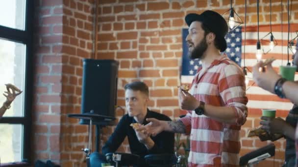 Музыканты едят пиццу во время репетиции — стоковое видео
