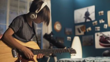 Genç yatak odasında gitar ile