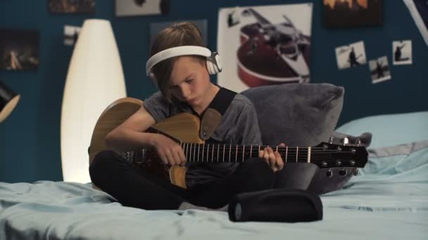 Niño en auriculares aprendiendo canción con guitarra — Vídeos de Stock