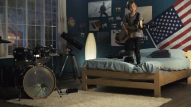 Etkileyici genç yatak odasında gitar çalmak