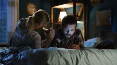 Genç çift sörf smartphone yatakta