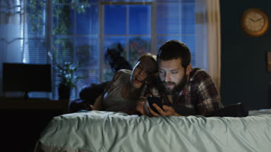 Genç çift sörf smartphone yatakta