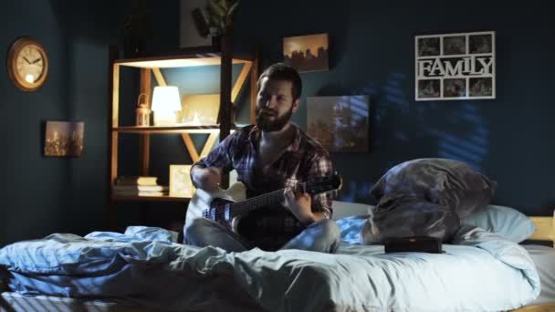 Casal brincalhão cantando com guitarra na cama — Vídeo de Stock