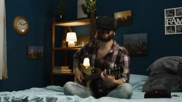 Homem tocando guitarra em óculos VR na cama — Vídeo de Stock