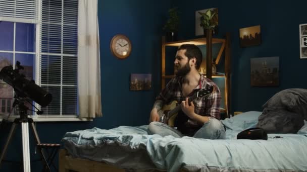 Casal brincalhão cantando com guitarra na cama — Vídeo de Stock