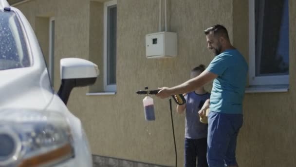 Homme avec fils lavage de voiture à l'extérieur — Video