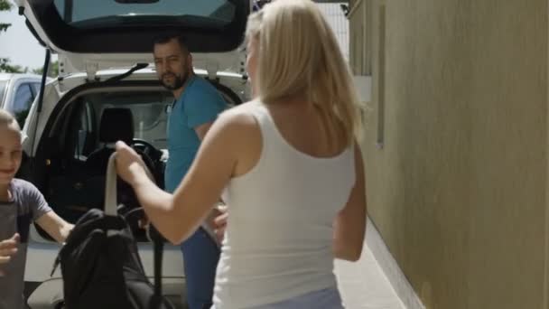 Famille joyeuse chargement de voiture avec des sacs avant les vacances — Video