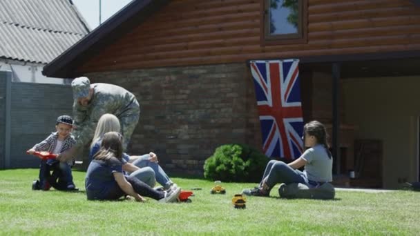 Солдат с семьей наслаждается временем на улице — стоковое видео