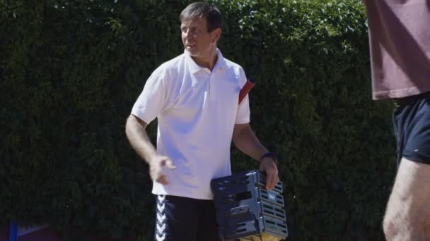 Entraîneur de tennis travaillant avec l'homme sur le terrain — Video