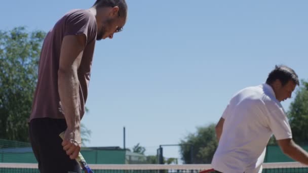 Tränare som visar badmintonracketens placering till mannen — Stockvideo