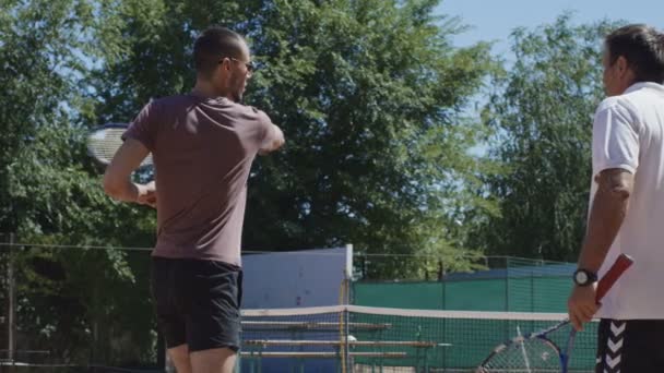 Entrenador de tenis trabajando con el hombre en la cancha — Vídeo de stock