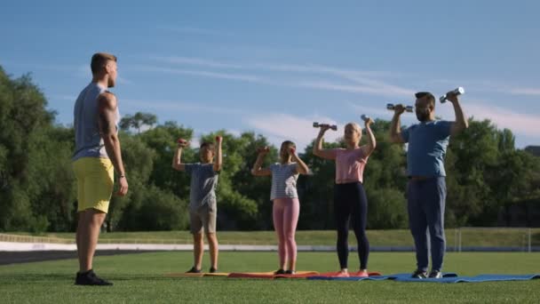 Man opleiding familie met kinderen op veld — Stockvideo