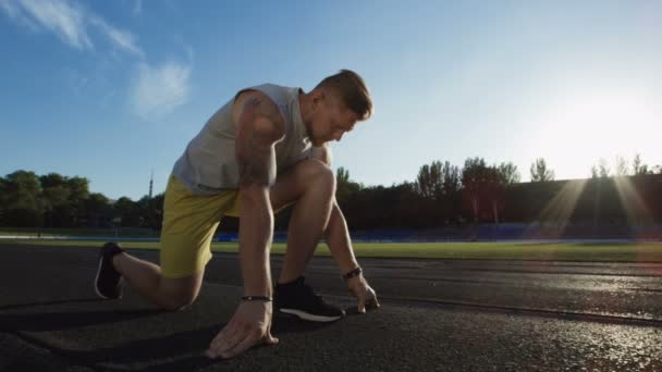 Tatuerade sportsman i crouch start på spår — Stockvideo