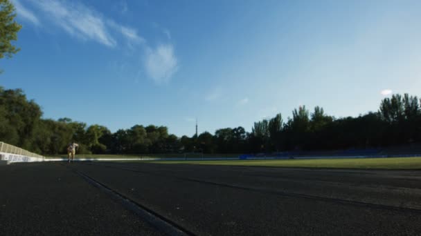 Sportlicher Mann läuft Sprint auf Rennstrecke — Stockvideo