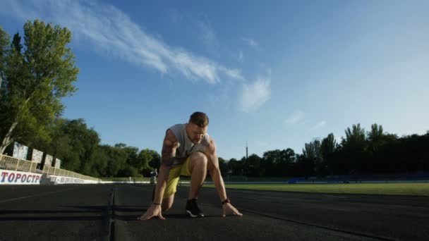 Tetovaný sportovec v podřepu start na trati — Stock video