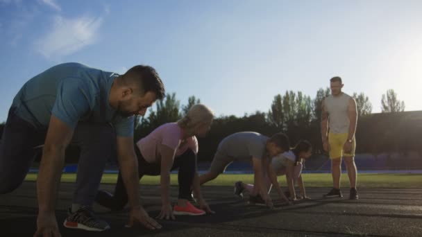 Familia corriendo sprint para el tiempo en el estadio — Vídeo de stock