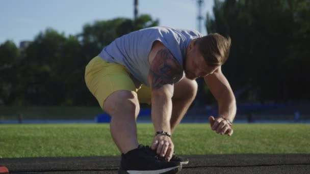 Спортивний спортсмен, що тягнеться на полі — стокове відео