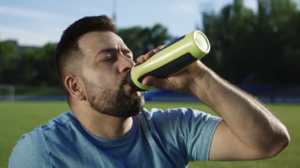 Mann trinkt Wasser im Stadion — Stockvideo