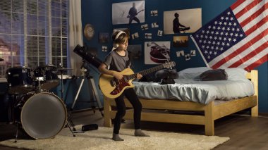 Etkileyici genç yatak odasında gitar çalmak