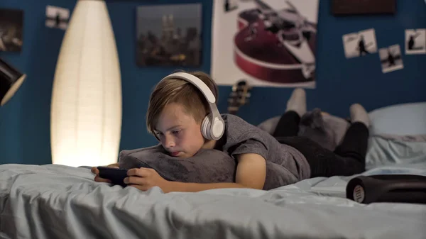 Junge spielt Smartphone im Bett — Stockfoto