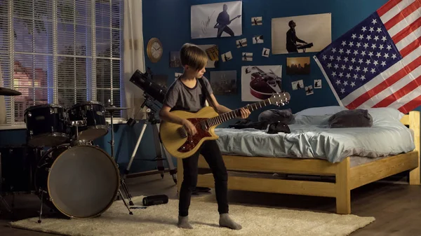 Expresivo joven tocando la guitarra en el dormitorio — Foto de Stock
