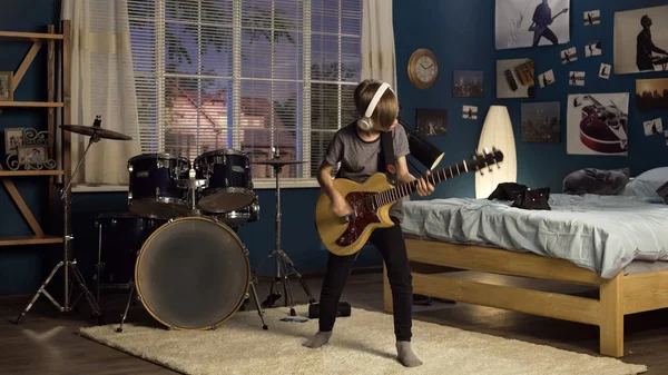 Jovem expressivo tocando guitarra no quarto — Fotografia de Stock