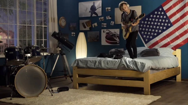 Etkileyici genç yatak odasında gitar çalmak