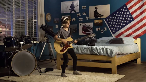 Виразний молодий грає на гітарі в спальні — стокове фото