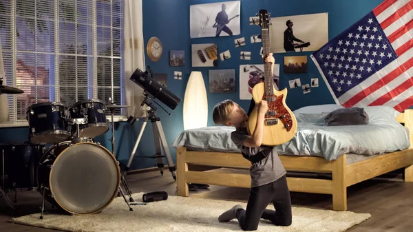 Etkileyici genç yatak odasında gitar çalmak