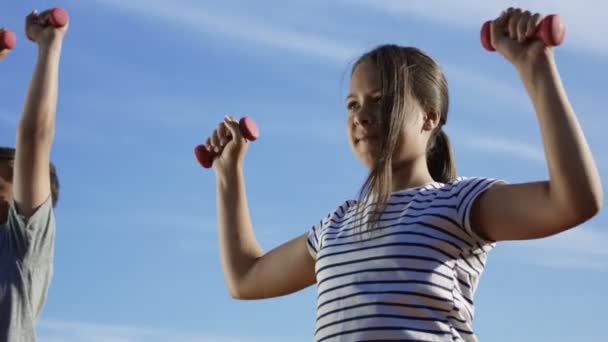Niños entrenando con pesas afuera — Vídeos de Stock