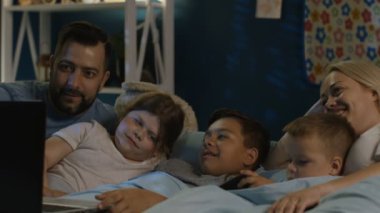 Dizüstü gece izlerken büyük mutlu bir aile