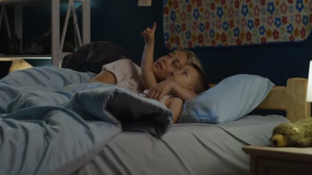 Женщина разговаривает с мальчиком перед сном — стоковое видео