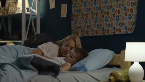 Mujer conseguir chico a la cama en la noche — Vídeo de stock