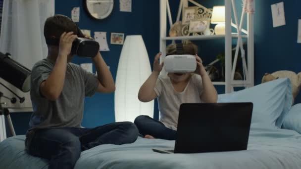 Crianças jogando videogame em óculos VR na cama — Vídeo de Stock