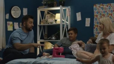 Adam hikayeleri aile için yatağa söylüyor.