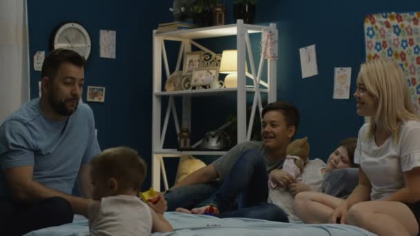 Člověk si říká příběhy rodiny na posteli — Stock video
