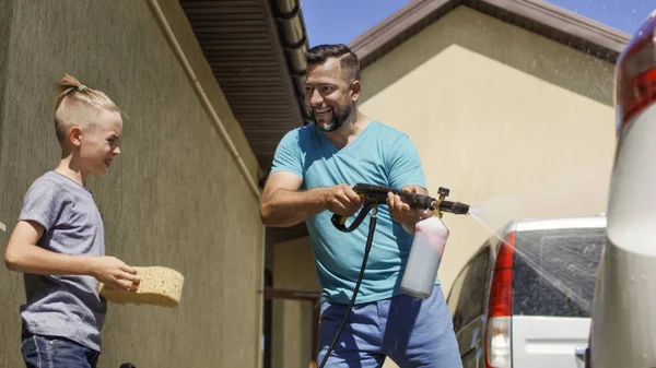 Hombre con hijo lavando coche afuera —  Fotos de Stock