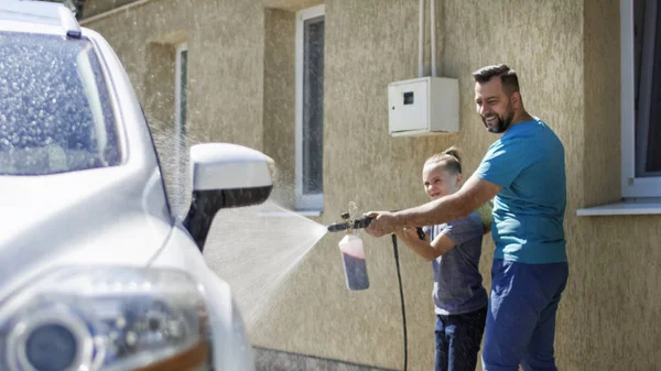 Hombre con hijo lavando coche afuera — Foto de Stock