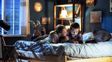 Genç çift sörf smartphone yatakta