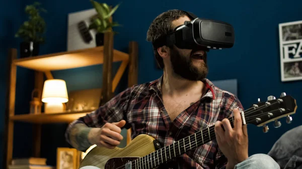 Hombre tocando la guitarra en gafas VR en la cama por la noche — Foto de Stock
